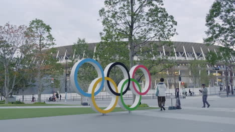 olympic rings sculpture in front of japan national stadium in tokyo