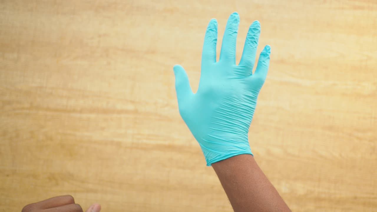 Putting on a blue medical glove