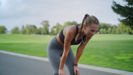 atleta discapacitado deteniéndose después de correr en el parque. mujer respirando después del entrenamiento
