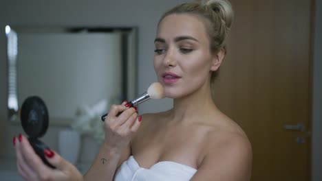 Woman-applying-powder-in-morning