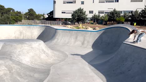 Vista-De-Cerca-De-Un-Joven-Patinador-Usando-Ropa-De-Moda-Saltando-En-Patineta-Desde-Una-Rampa-Alta-Y-Luego-Aterrizando-Sin-éxito