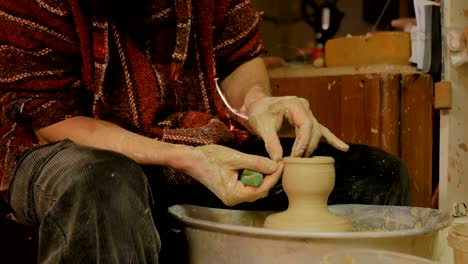 professional male potter working in workshop, studio