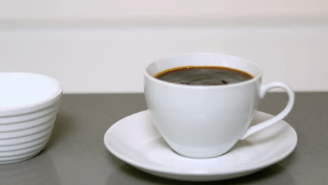 azúcar vertiendo en la taza de café