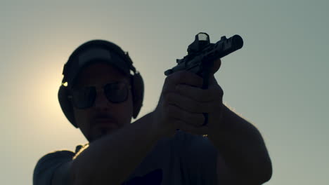 man firing pistol in silhouette