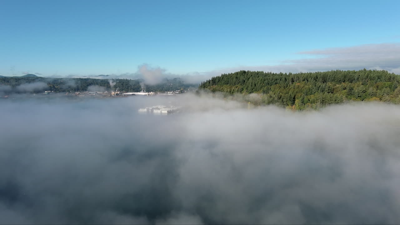 Aerial view from a drone hovering above haze on Puget Sound, showcasing the silhouette of the distant mountain range. The atmospheric conditions create a peaceful and picturesque scene
