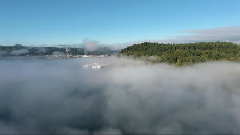 aerial view from a drone hovering above haze on puget sound, showcasing the silhouette of the distant mountain range. the atmospheric conditions create a peaceful and picturesque scene