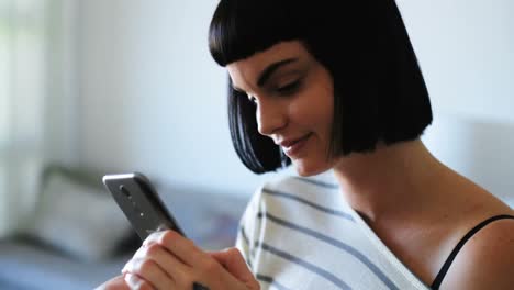 woman using mobile phone in living room 4k