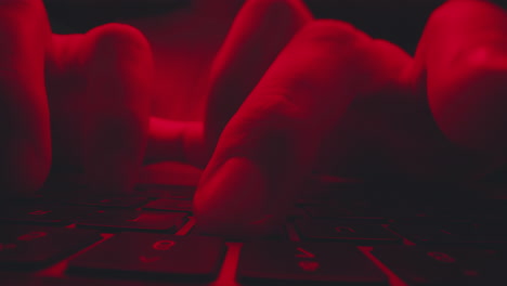 persona escribiendo en un teclado por la noche