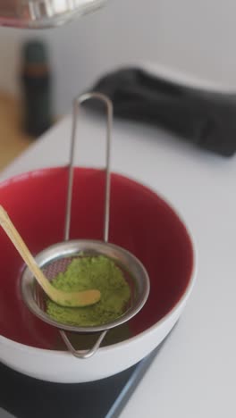 sifting matcha powder for tea preparation