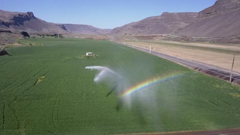 el agua de la rueda de riego de cultivos produce un arco iris vibrante en el cañón