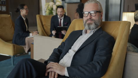 Businessman Relaxing in Hotel Lobby
