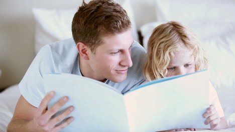 father reading a book with his son