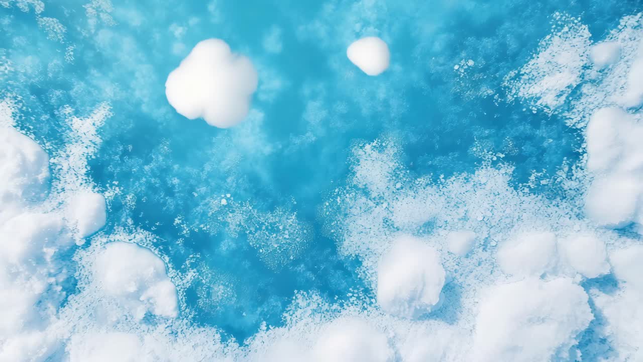 Top-down view of icy blue water with floating snow patches, creating a serene winter scene