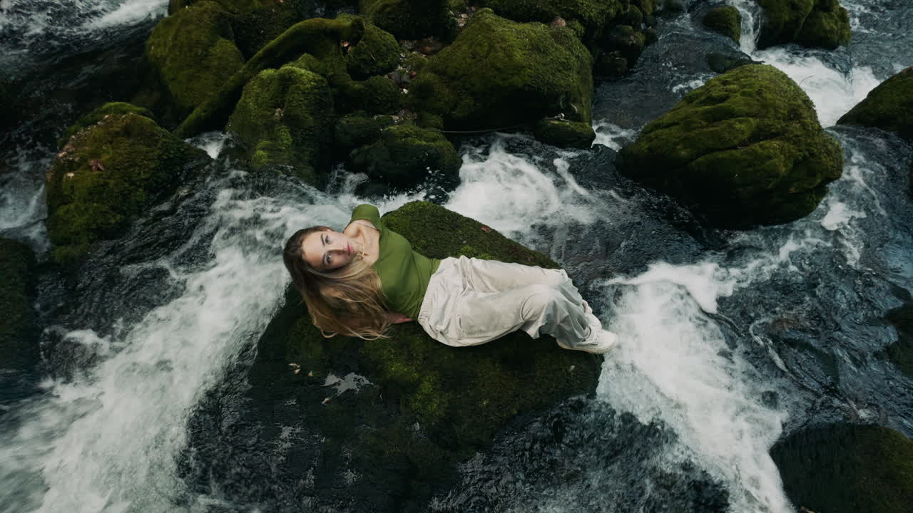 Woman Relaxing by a Waterfall