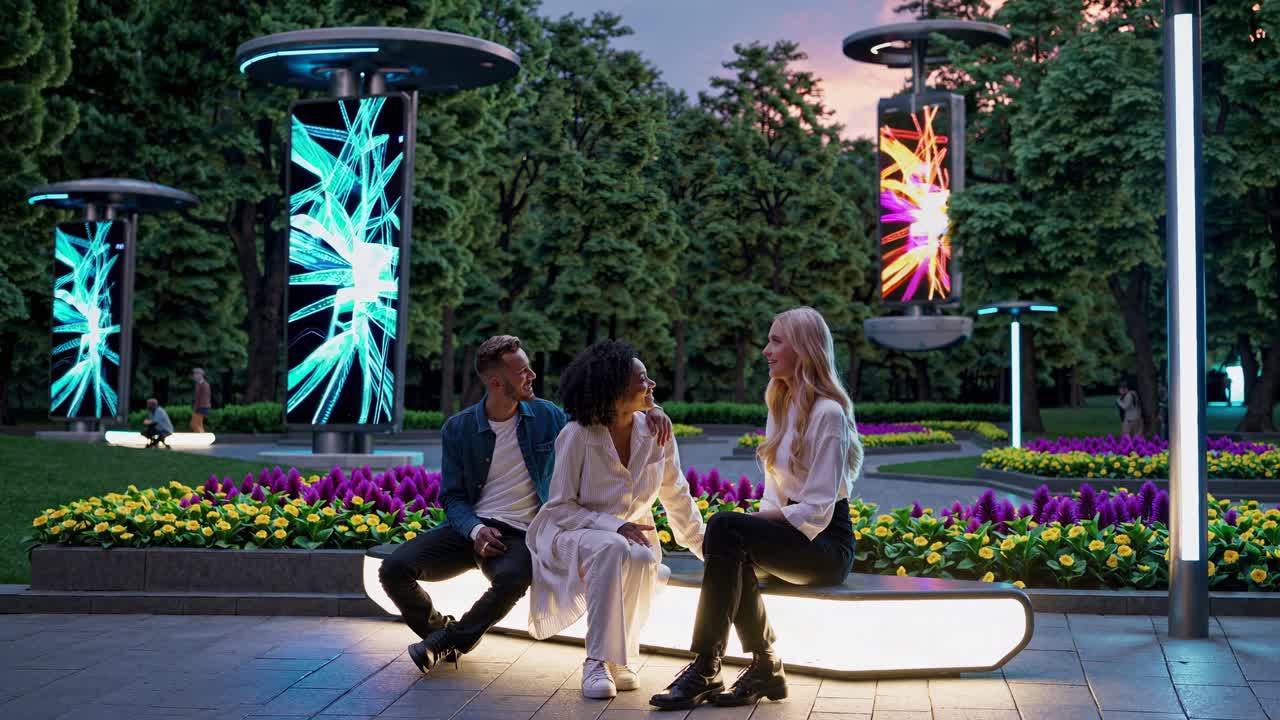 Friends Relaxing in a Modern Urban Park at Night with Interactive Displays