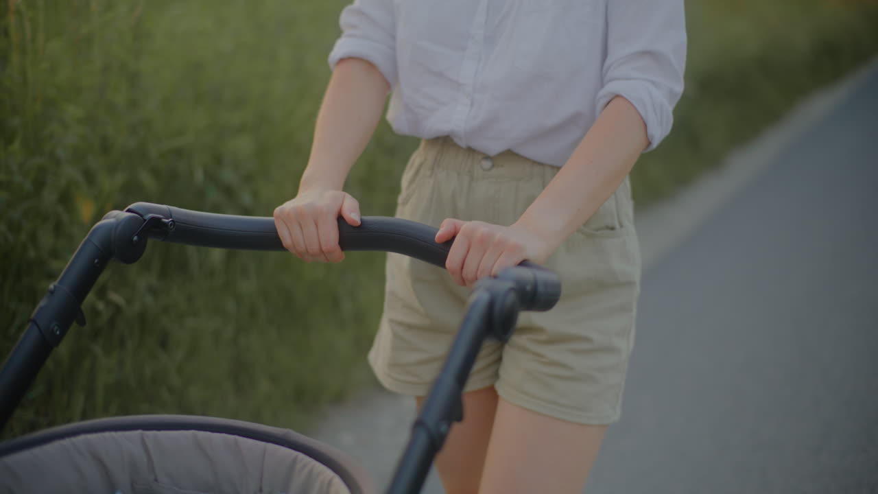Close-up of Woman Pushing Baby Stroller at Sunset