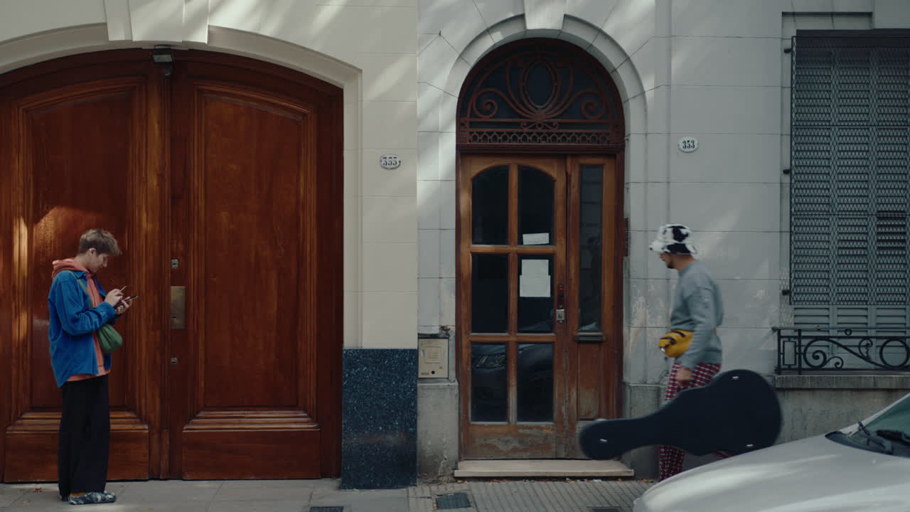 Man with Guitar in Case Walking and Entering House