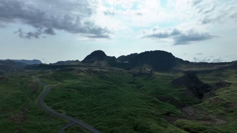 road by the lush green mountains in thingvellir national park in iceland