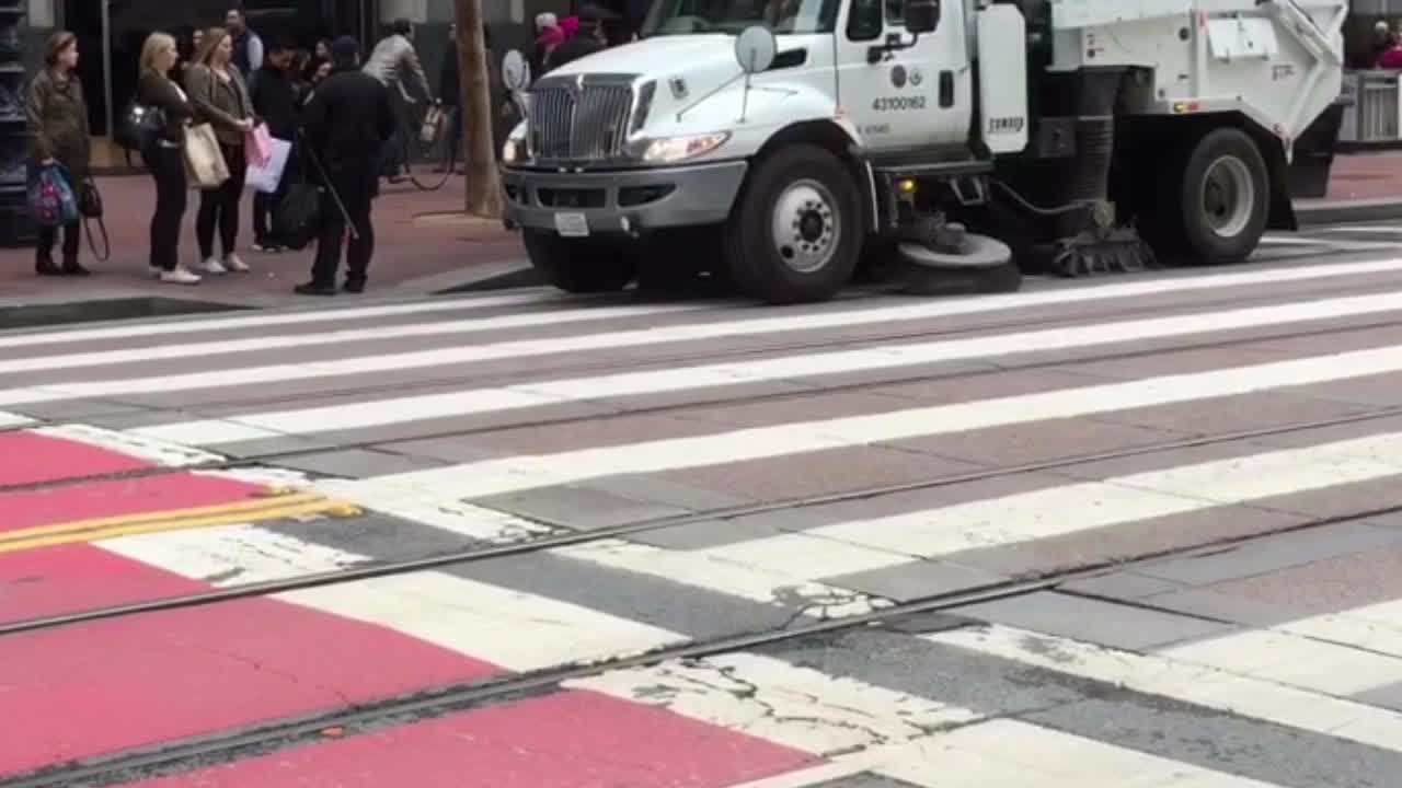 Department of Public Works road surface cleaning trucks doing their work on Market Street in San Francisco California