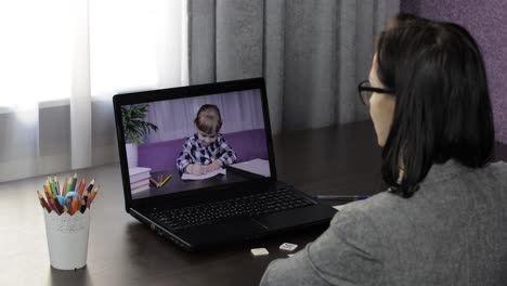 la maestra hace una llamada de video en la computadora portátil con los niños del alumno. educación a distancia
