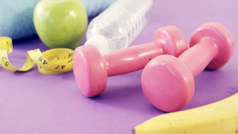 fruits, napkin, measuring tape, dumbbells and water bottle