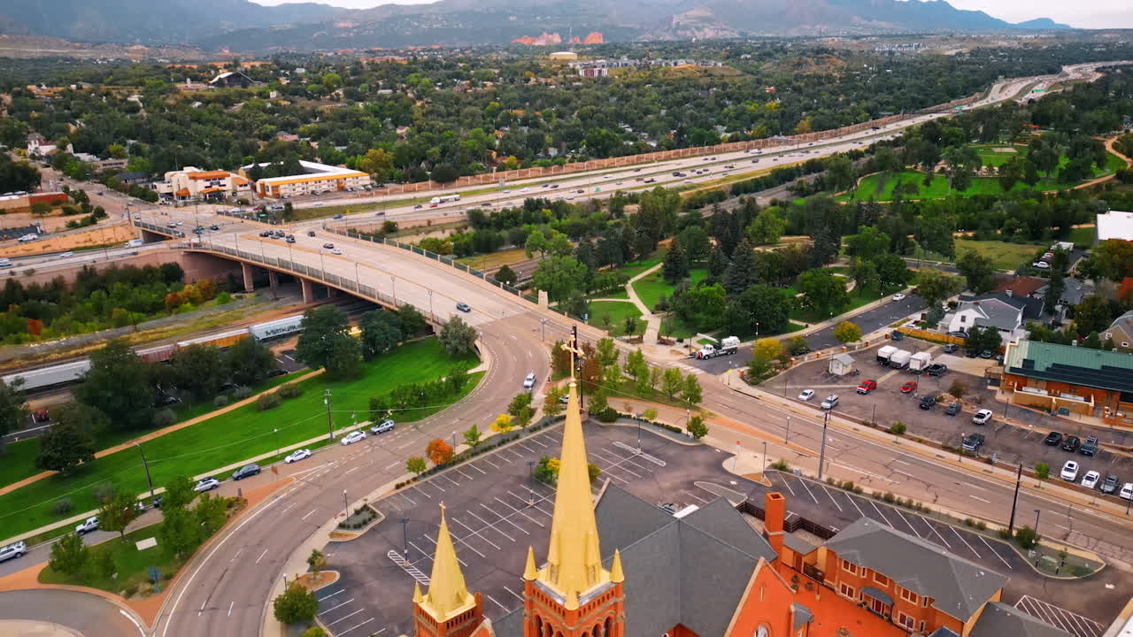 Footage at the golden steeples with crosses of the church. Aerial perspective on the hectic traffic on the roads. Colorado Springs, Colorado, USA