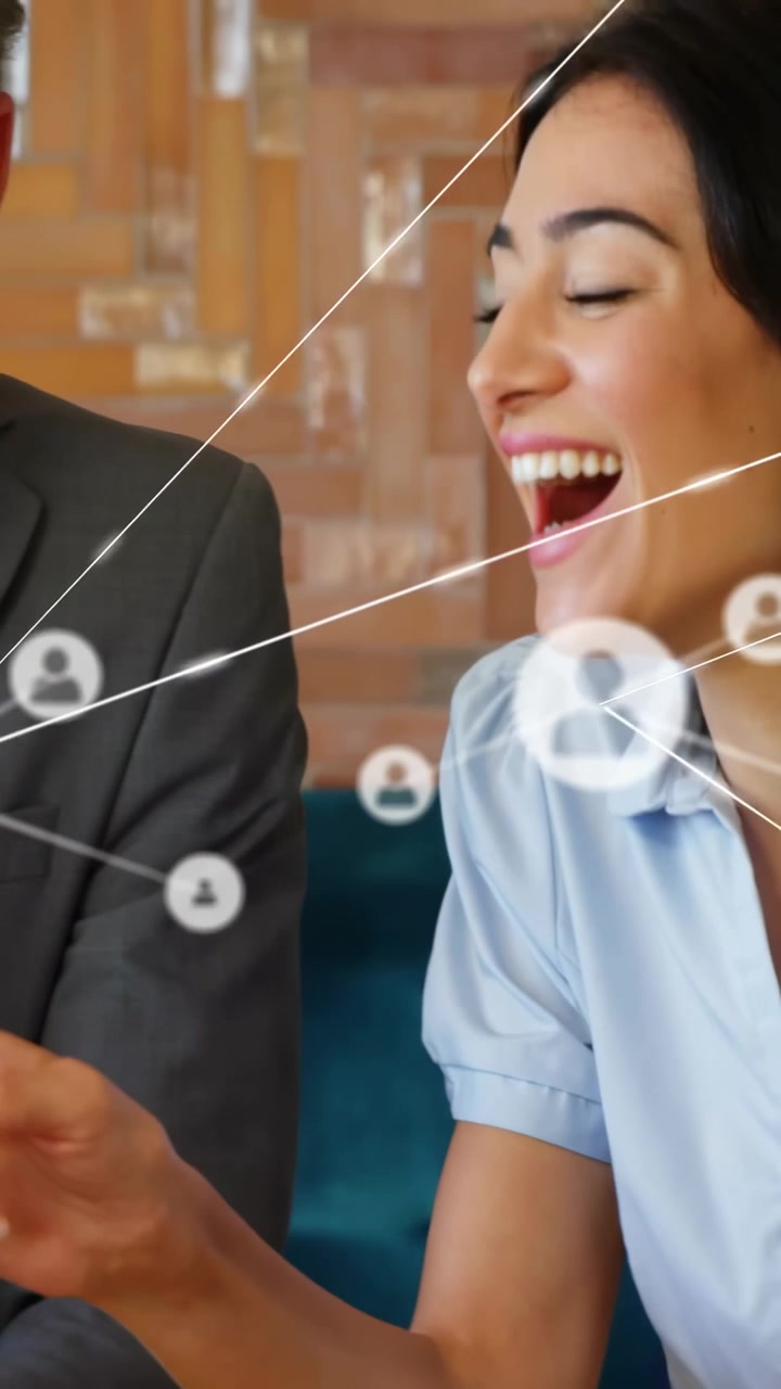 Video verticale: Uomo che tocca il telefono e donna che si sporge, mostrando icone di rete aziendale intorno al telefono.