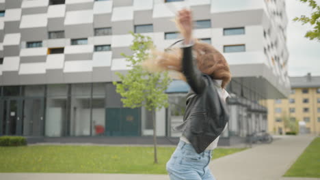 stylishly dressed woman having fun outdoor in jeans outfit looking happy and pleasant jumping and