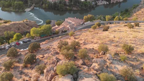 Elevándose-Revelan-Sobre-El-Punto-De-Vista-De-Piedra-Del-Moro-En-Toledo-,-Calentando-La-Puesta-De-Sol-Sobre-La-Ciudad