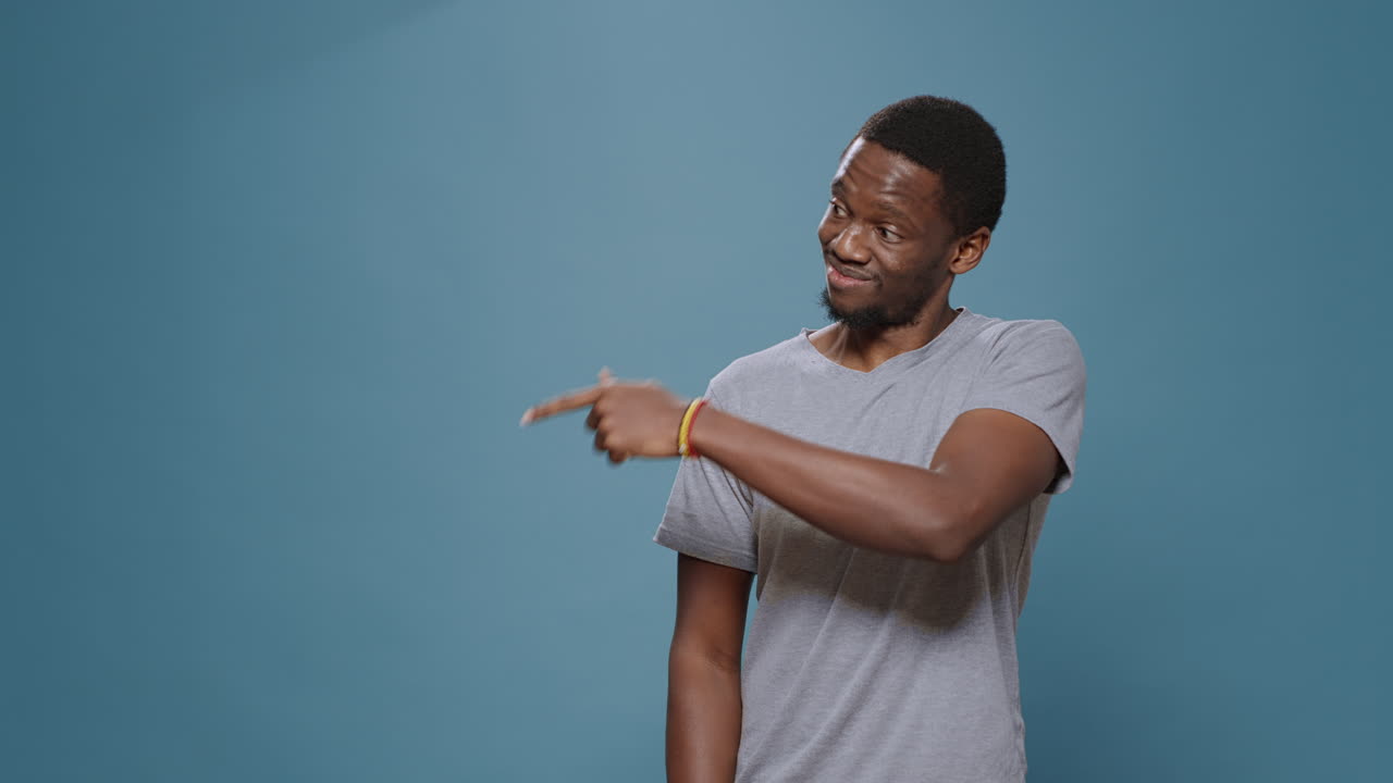 Confident adult pointing at left and right side over blue background