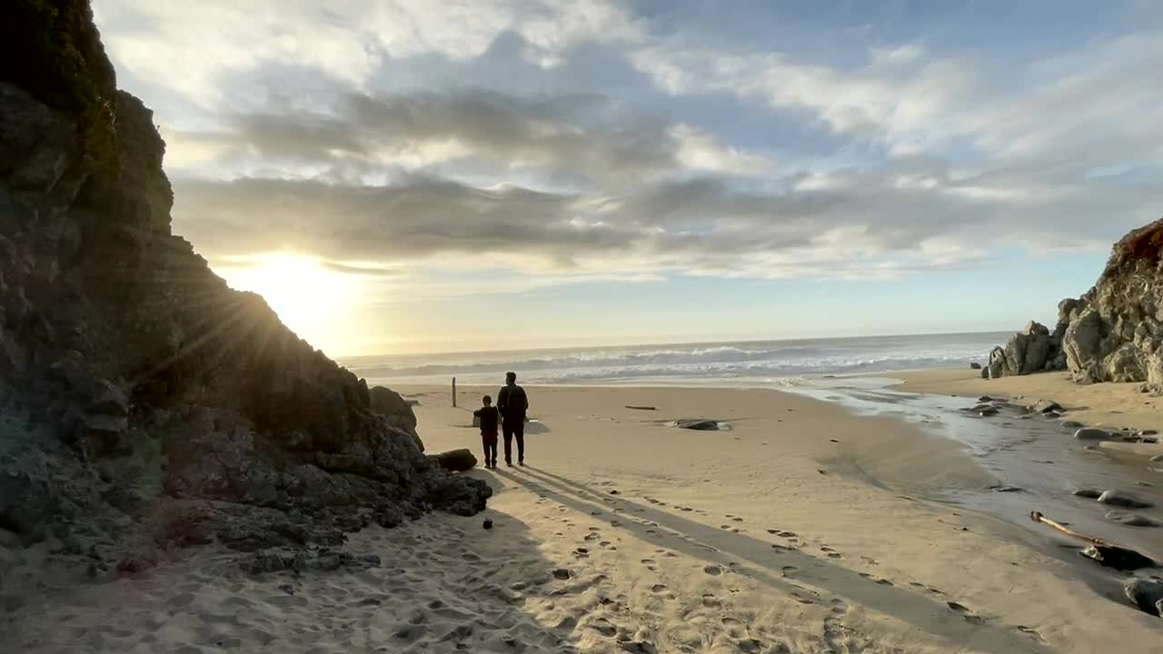 big sur viajes y turismo, padre e hijo viendo la puesta de sol en el océano