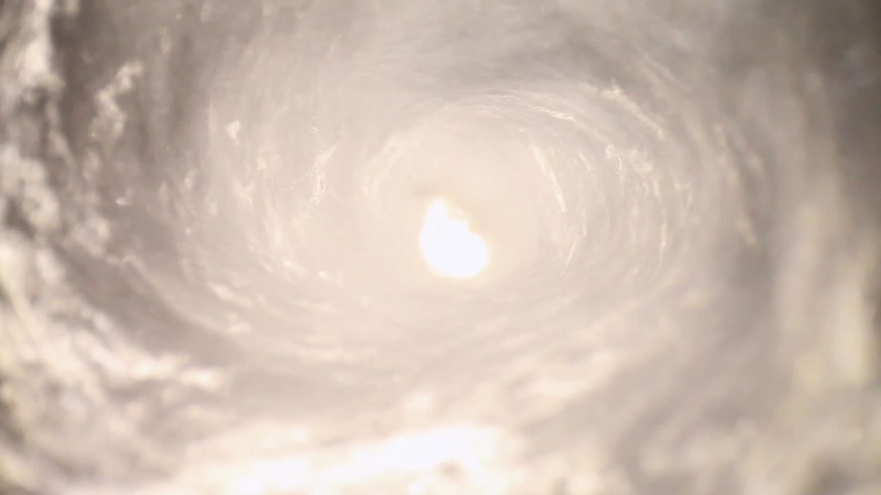 물로 채워진 블렌더에 잠긴 물은 시계 반대 방향으로 빠르게 소용돌이 치고 있습니다. 광각 프로브 렌즈를 사용하여 독특한 관점을 얻습니다.
