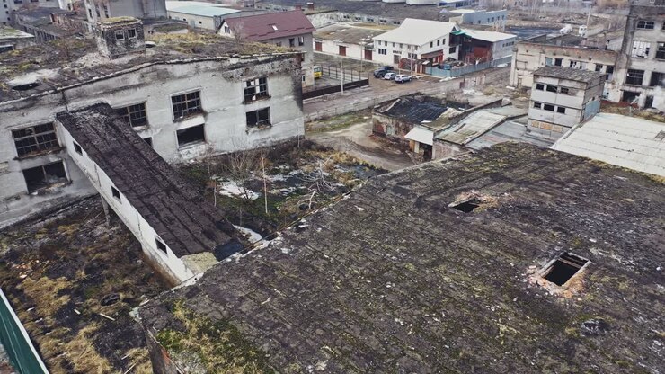 Voo sobre a fábrica destruída. Antigo prédio industrial para demolição. Vista aérea.