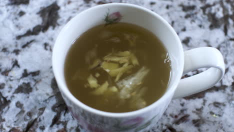 swirling ginger and lemon pieces in honey hot drink