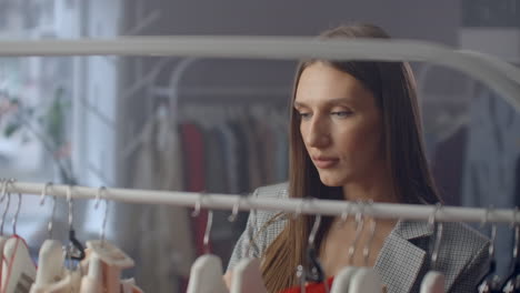 Una-Hermosa-Mujer-Elige-Ropa-En-Una-Sala-De-Exposición-De-Ropa-De-Marca.