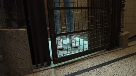 Female-feet-opening-the-door-of-the-ancient-vintage-elevator,-walks-in-and-descends---Close-up