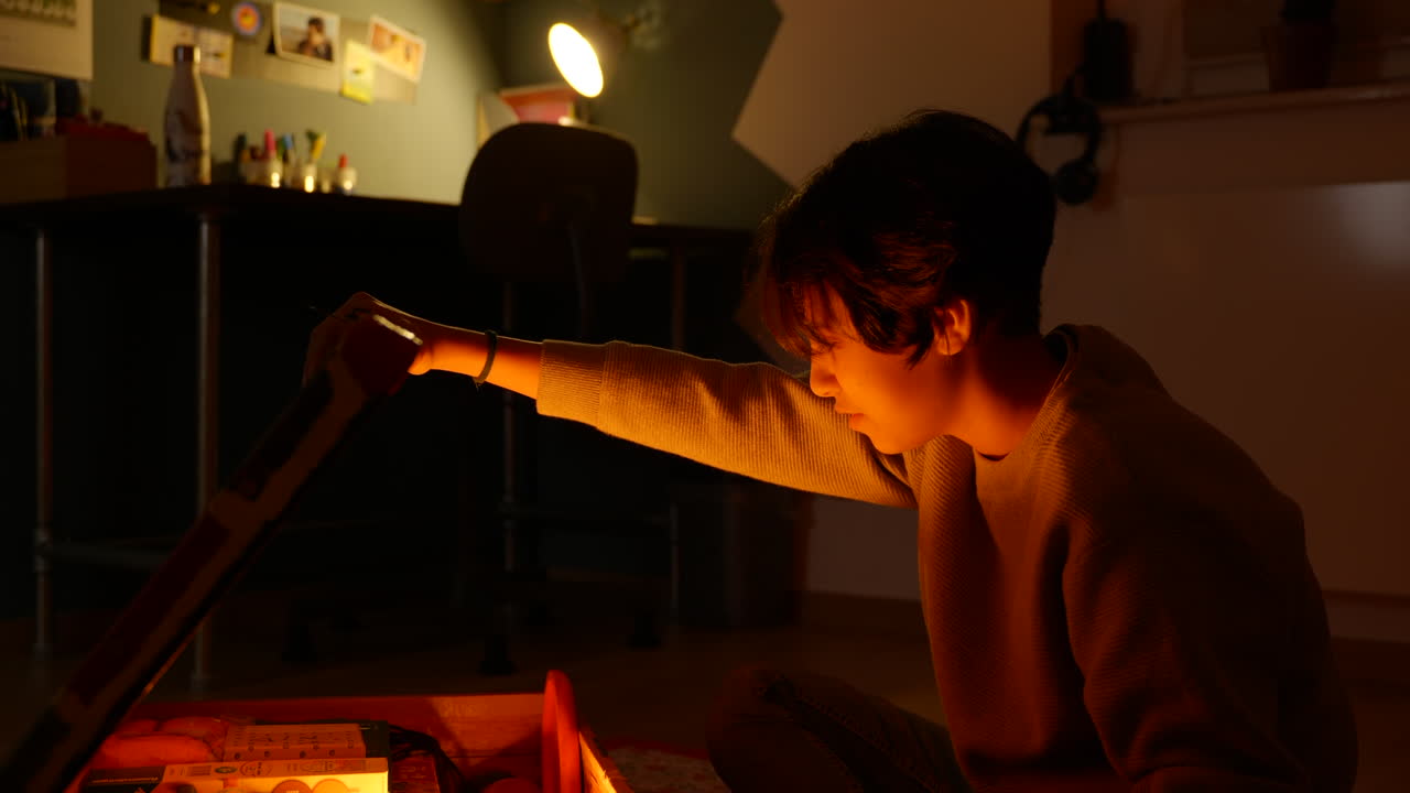 10대 소녀가 마법의 장난감 상자를 열고 마법에 걸린 빛나는 금빛으로 뚜껑을 들어올리며 놀란