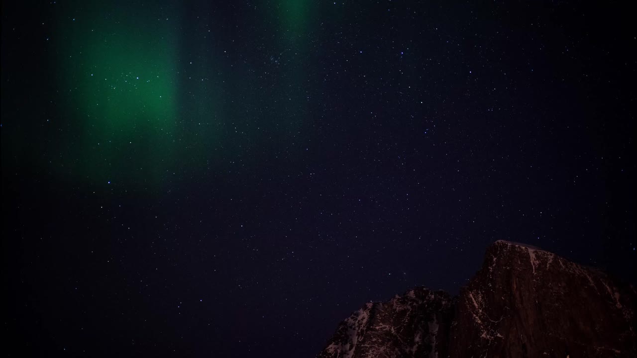 Northern Lights Aurora Borealis Displayed in Earth's Sky above Mountain Tops