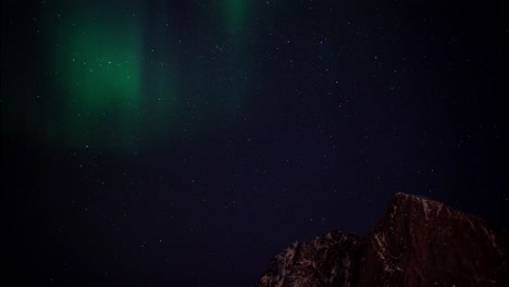 northern lights aurora borealis displayed in earth's sky above mountain tops