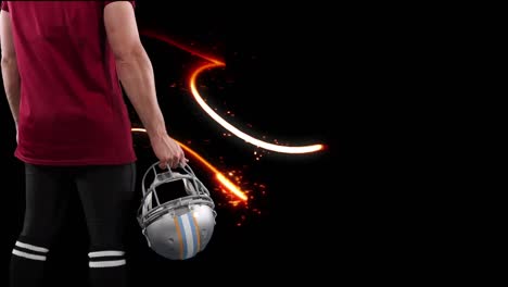 american football player holding helmet over light trails