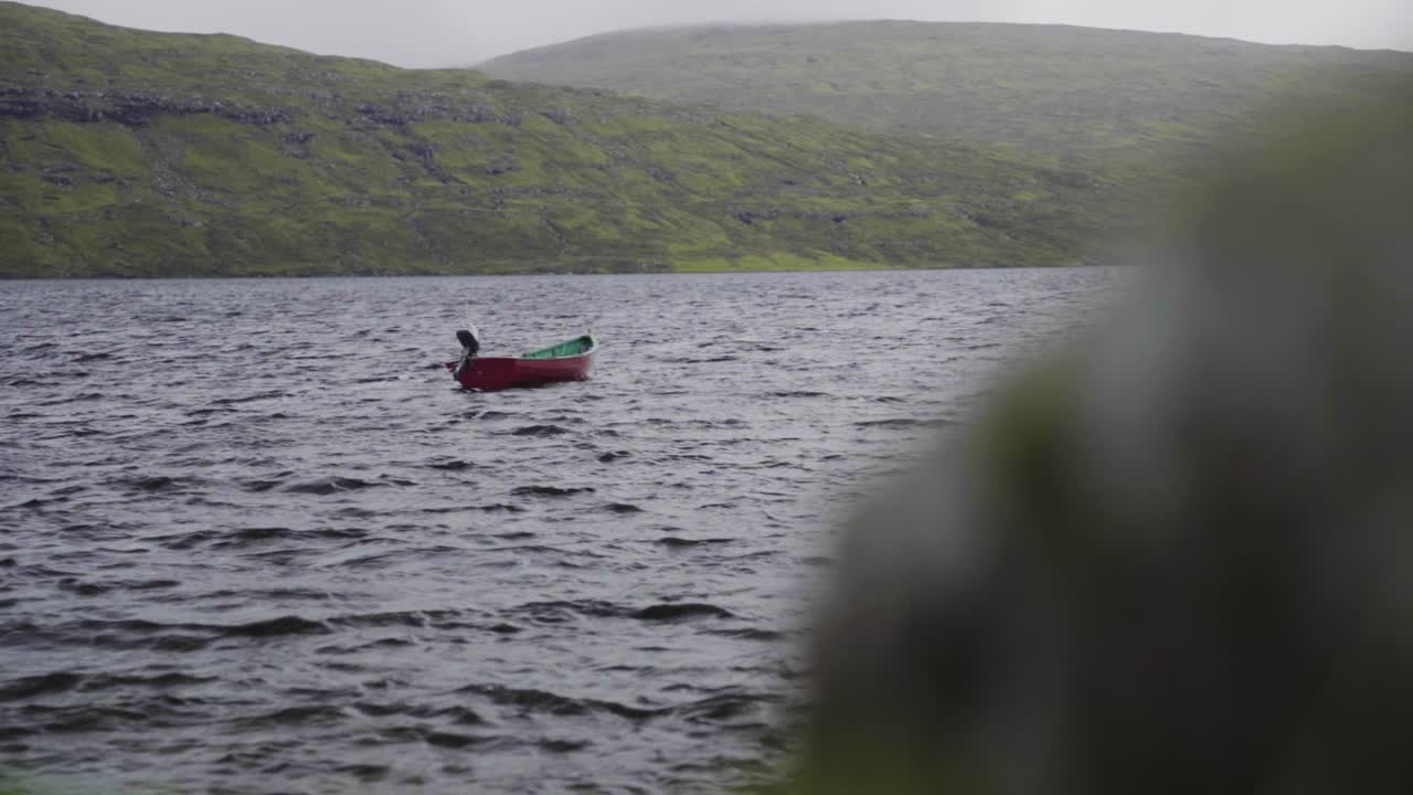 одинокая гребная лодка плывет по глубокой воде с небольшими волнами утром