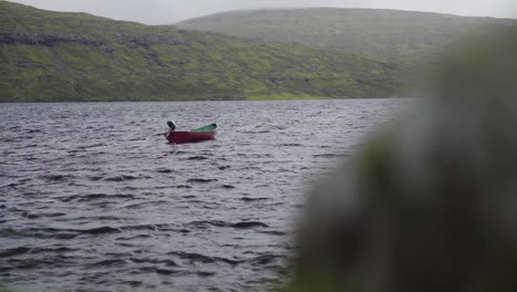 lonely row boat floating on deep water with small waves in the morning