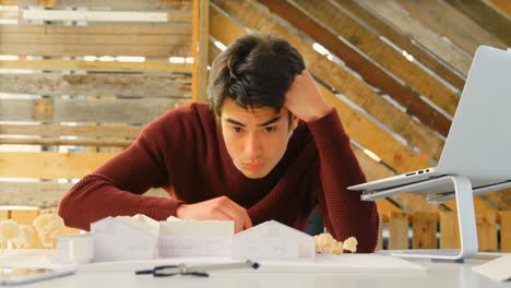 ejecutivo trabajando en un modelo arquitectónico en la oficina 4k