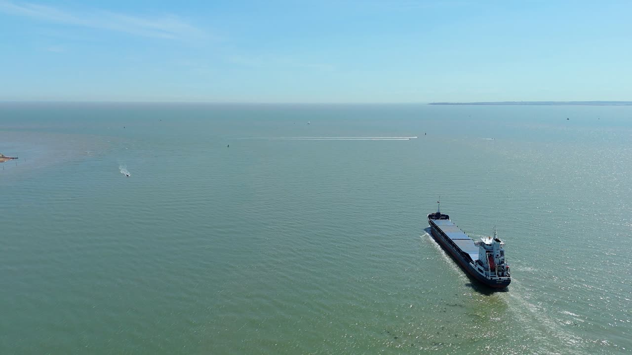 Aerial drone view of a large container ship cargo vessel leaving Felixstowe port in England heading into the North Sea, shipping and export, sunny summer day