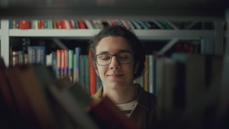 retrato de un joven estudiante de la generación z detrás de una estantería en la biblioteca de la universidad