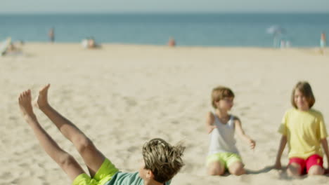 slow motion di un ragazzo che lancia e calcia una palla da calcio sulla spiaggia