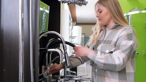 woman examining faucets in a showroom