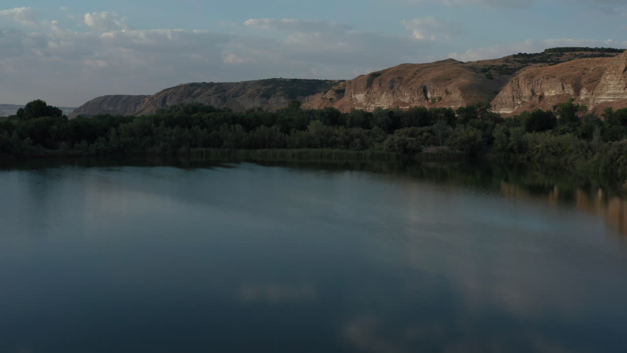Aerial shot of Spanish lagoon or lake at sunset. Drone panning shot