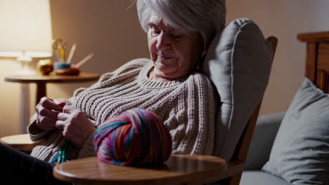 elderly woman knitting with yarn