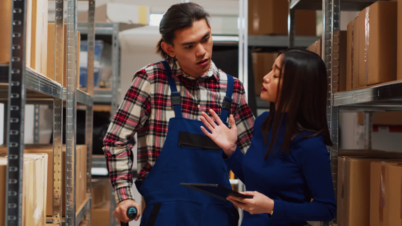 Warehouse workers discussing inventory with tablet
